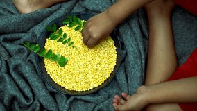Nuts and neem leaves ( paripp ) in a bowl and the child's hands. 4k stock video footage from Kerala India