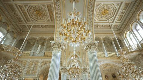 SAINT PETERSBURG, RUSSIA - JUNE 18, 2021:  Crystal golden chandeliers. Interior of Hermitage museum, Winter Palace, Saint Petersburg. Historic art, culture tourism, family travel destination in Russia