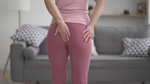 Hemorrhoidal pain, woman suffering from hemorrhoids at home