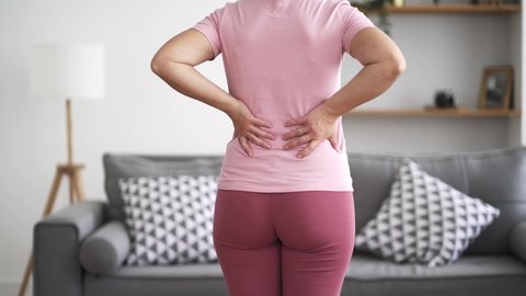 Back pain, kidney inflammation, woman suffering from backache at home, health problems concept