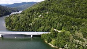 Lake bridge. Cars on th road. View of the Ruzin reservoir on the outskirts of Kosice. River and trees. Top down view. Drone Video. Slovakia. Europe