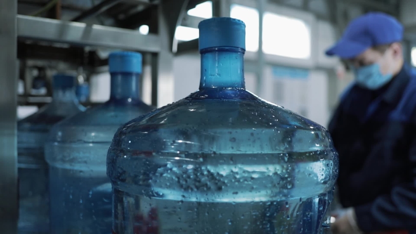 Production. Filling open necks of PET bottles with water. Large empty plastic bottle. 5 Gallon Refillable Bottles Clean Water Bottle On Conveyor. Royalty-Free Stock Footage #1082272535