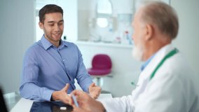 Grateful happy young male patient shaking hand of smiling mature doctor in white coat after successful consultation, thanking for help or feeling excited about healthcare treatment results at meeting. - Powered by Shutterstock - Get 15% off with code: PIKWIZARD15