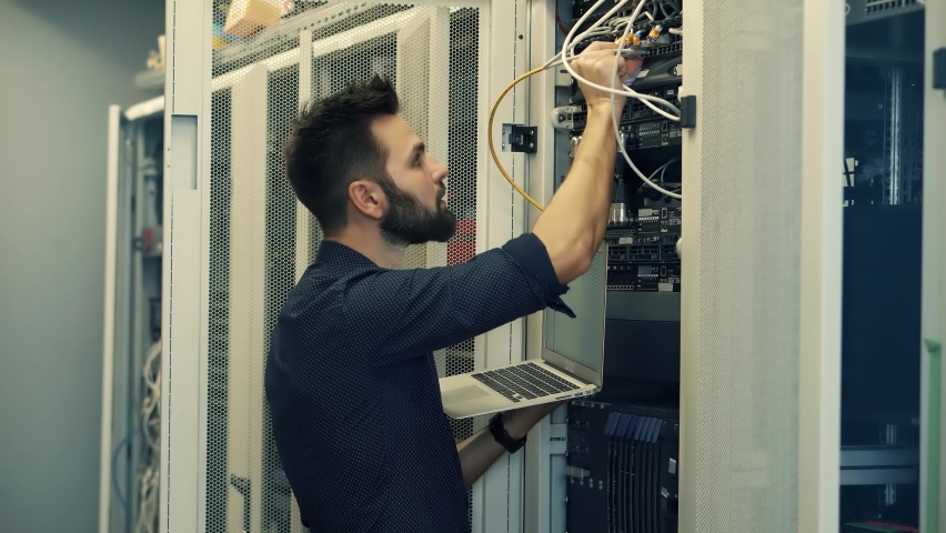 Technician Testing Network Connection. Hardware Updates On Server Room. Engineer Connect Network Cable To Switch. Data Center Network Cable Network Technology. System Administrator Configures Ethernet Royalty-Free Stock Footage #1082282278
