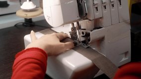 A professional seamstress sews the fabric. A woman works on a sewing machine close-up. Sewing process.