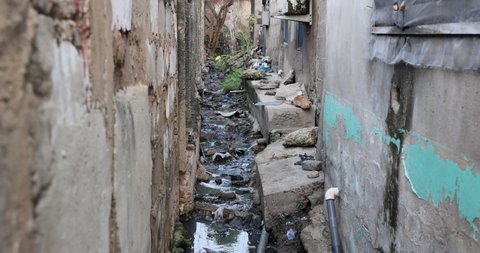Poverty filth home raw sewer ditch Accra Ghana. Historical busy congested market residential area Accra, Ghana. Pollution and garbage. Homes low income poverty of Africa.