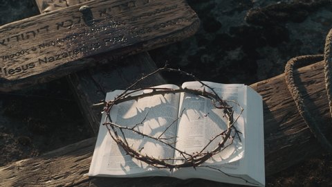 From above opened Holy Bible and crown of thorns placed on wooden cross after Jesus Christ crucifixion