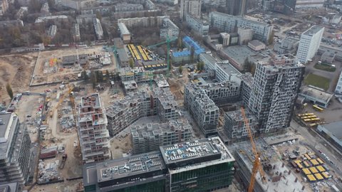 High crane works on building site with a house. Urban Construction Site, Aerial View. Construction area, building area, site area from above. New appartments getting built