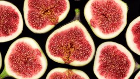Sliced fresh figs top view, rotation. Figs Isolated on black Background. Healthy food concept. 4K UHD video 