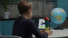Autistic boy building with color wooden blocks using tablet computer. Online assignment to pupil with autism. Applied behavior analysis for students with autism. Over the shoulder view. - Powered by Shutterstock - Get 15% off with code: PIKWIZARD15