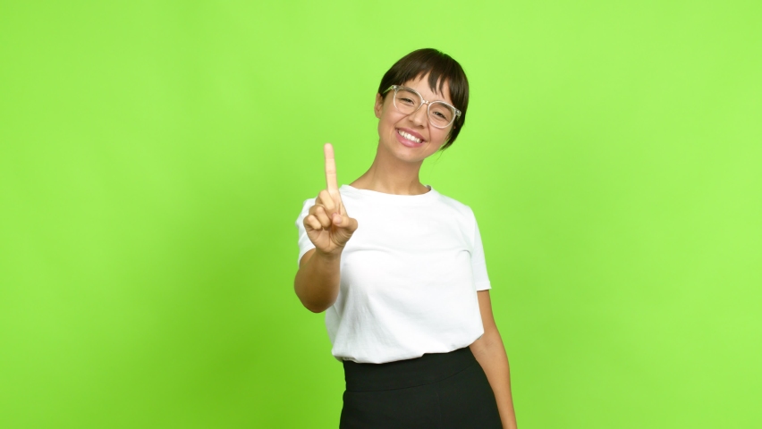 Young woman happy and counting with fingers over isolated background. Green screen chroma key Royalty-Free Stock Footage #1082293159