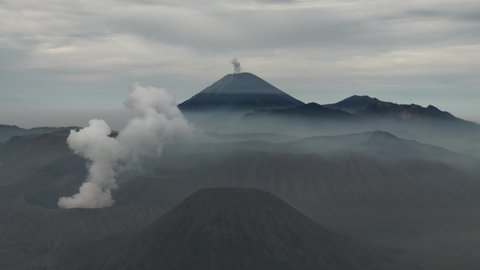 Morning fog in the Bromo caldera. Clouds over Batok volcano. In the background the volcano Semeru. Timelapse of Bromo Volcano