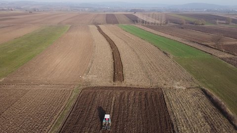 aerial shot of arable land and a small tractor