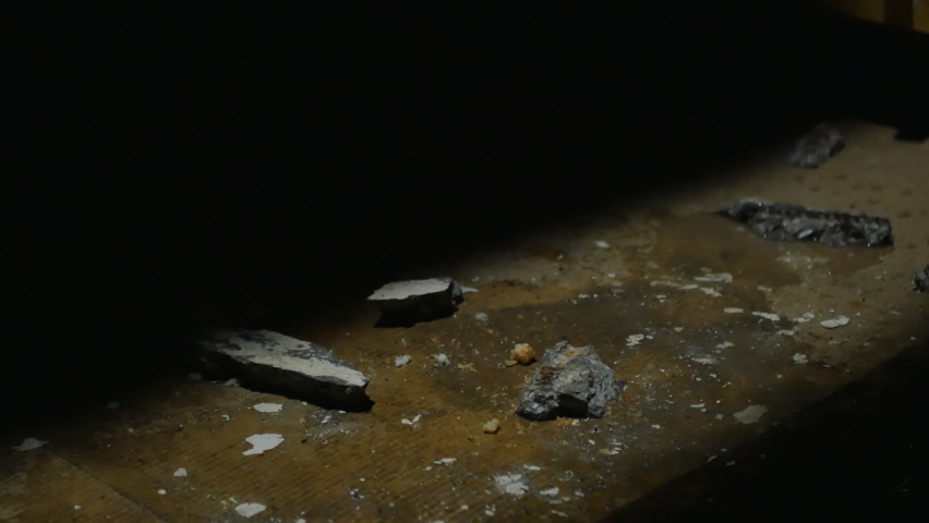 the hand of an imprisoned captive in the basement emerged from the darkness and took a piece of bread thrown to the man for food. Illegal slavery and kidnapping concept.