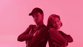 Professional choreographers portrait. Man and woman dancers posing on color changing neon background, pair dance, duet. Modern dance school for teenagers. Young happy couple smiling close-up.