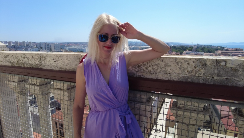 Woman with hat on top view of Zadar city of Croatia on Adriatic Sea and capital of Dalmatia. Panoramic terrace of Cathedral bell tower Katedrala Sv. Stosije. Aerial view of the cityscape in summer.
