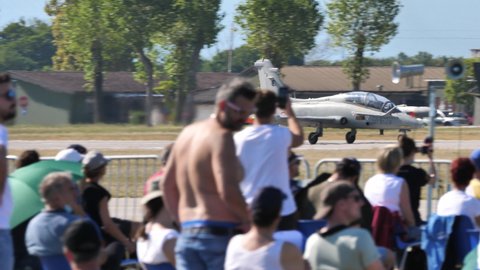 Rivolto, Udine, Italy SEPTEMBER, 18, 2021 Audience at one of the few airshows held during the coronavirus outbreak admires a military jet taking off. Aermacchi MB-339 of Italian Air Force