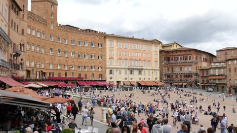 Siena, Tuscany, Italy JULY, 15, 2016 Crowd of tourists visiting the wonderful Piazza del Campo in Siena where the Palio is held. 4K pan video from left to right