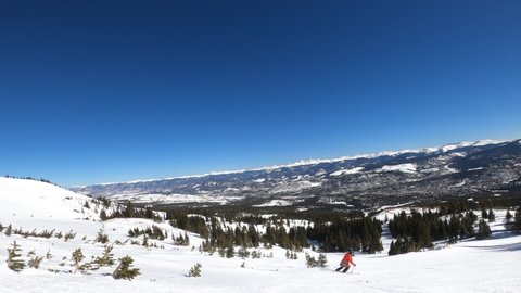 Skier in red jacket going downhill in Breckenridge Ski Resort Colorado.