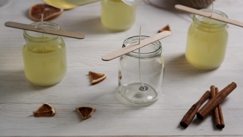 Pouring melted soy wax in glass. Crafting natural candle at home. Hobby. | Shutterstock HD Video #1082319898
