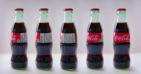 Calgary, Alberta, Canada. Nov 14, 2021. Rotating Bottles of Coca Cola of 237 ml on a clear background