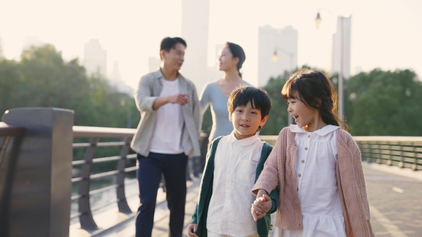 happy asian family with two children walking on a bridge outdoors in city park Royalty-Free Stock Footage #1082326534