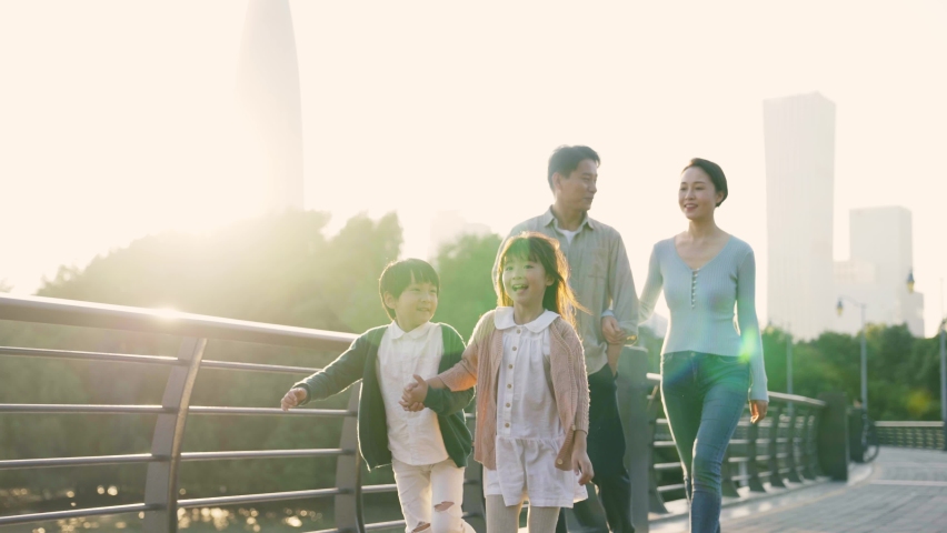 happy asian family with two children walking on a bridge outdoors in city park Royalty-Free Stock Footage #1082326537