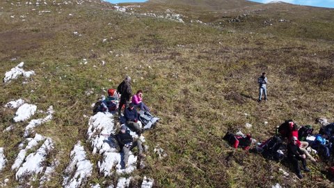 Aerial video from a drone, active hikers on a halt in the Caucasian mountains of Abkhazia, on the Arabica plateau. Young people conquer the peaks of the Caucasus.