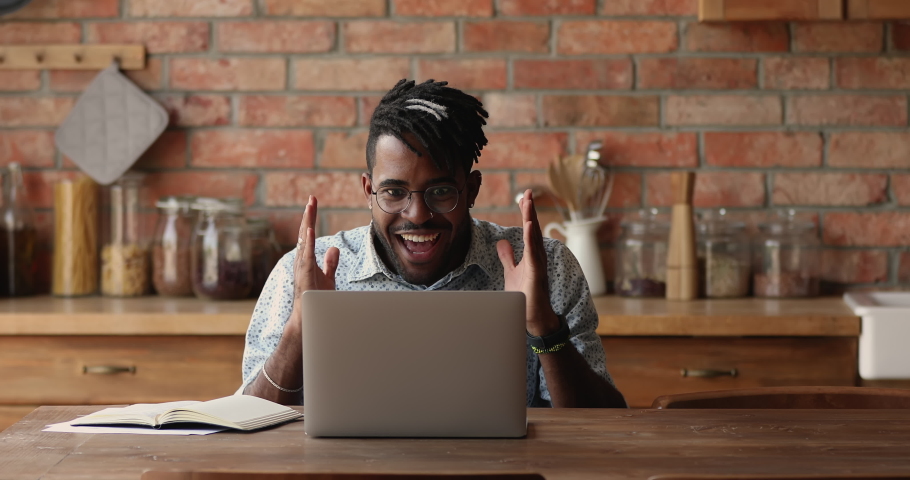 Excited African man winner look at laptop celebrate business success, online victory, get great opportunity, career growth, sit at table at home, read good news got new job offer, reach result concept Royalty-Free Stock Footage #1082335540
