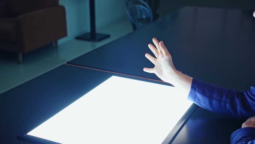 Businessman watching a blight screen in the dark office. Stereoscopic vision. Heads up display.