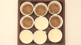 Cup cake base being spread with cream cheese