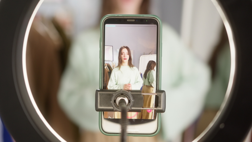 Girl take a selfie on a phone in room with tripod lamp selfie stick, student dance and sign in front of camera, use mask application film maker and streaming happy blogger fun activity challenge Royalty-Free Stock Footage #1082347372