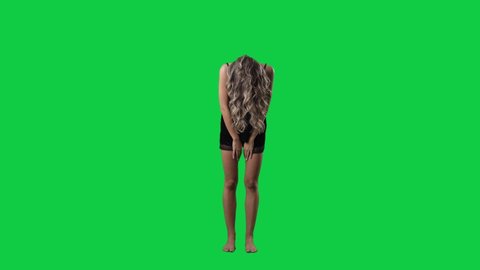 Super slow motion of woman in black pajama throwing back head tossing long hair. Full body isolated on green screen background