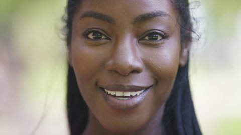 Close portrait of beautiful black female talking directly to camera 