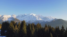 Mont Blanc mountain in Chamonix, France with fir and spruce tree in foreground. Scenic alpine mountain landscape. 4k 60 fps video footage.