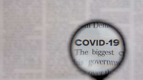 Health news text covid 19 newsletter through lens magnifying loupe. Read newspaper article headline covid news letter. Newspaper headline news coronavirus pandemic information search magnifier glass