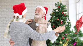Senior Caucasian couple dancing and smiling together in happiness during Christmas holiday while wearing Santa hat for season celebration - Powered by Shutterstock - Get 15% off with code: PIKWIZARD15