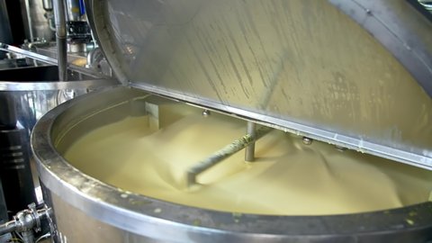 Butter production. Automated equipment mixing dairy product for making butter. Process of making fresh butter on a milk farm. Close-up.