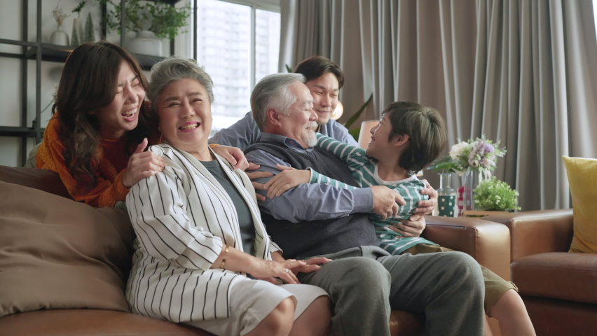 Happiness asian multi generation family,grandparent grandchild hug kissing together with love tenderness care giving spent time together three generations people having fun together, sitting on couch | Shutterstock HD Video #1082367265