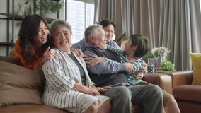 happiness asian multi generation family,grandparent grandchild hug kissing together with love tenderness care giving spent time together three generations people having fun together, sitting on couch - Powered by Shutterstock - Get 15% off with code: PIKWIZARD15