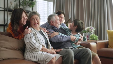 happiness asian multi generation family,grandparent grandchild hug kissing together with love tenderness care giving spent time together three generations people having fun together, sitting on couch
