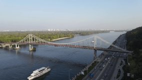 Yacht river bridge Kyiv Ukraine aerial drone view. Flight over the Dnieper river with a passing tourist boat 