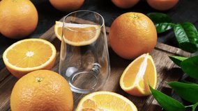 Fresh orange juice is poured into a glass. Fresh Orange fruits with green leaves on a wooden background. Healthy vegan food. Vitamins food.Ripe oranges. - Powered by Shutterstock - Get 15% off with code: PIKWIZARD15