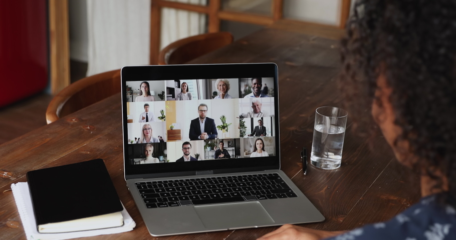 Diverse businesspeople engaged in group video call, laptop screen view over African businesswoman sit at desk take part in videoconference by business. Remote communication, videocall event concept Royalty-Free Stock Footage #1082378518