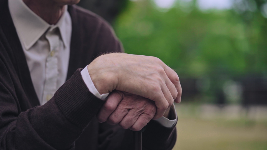 Hands of elderly man holding walking cane, lonely pensioner sitting park bench | Shutterstock HD Video #1082379145
