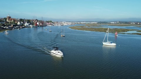 boats in the water of the blackwater estuary by the village of Maldon, Essex, England. speedboats and sailing ships on calm water on a sunny autumn day