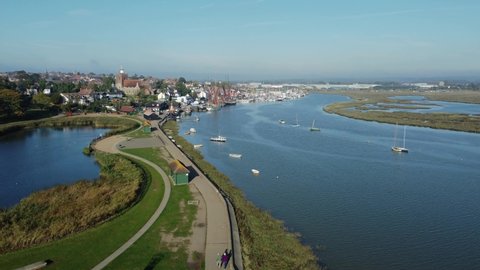View of Maldon town seen from above. People walking on the promenade. Boats and ships on the water at Blackwater estuary Essex, England. Drone aerial birds eye view shot