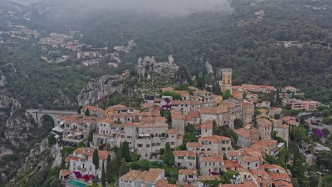 Eze France Aerial v18 establishing dolly in shot, drone flyover hillside, cliffside medieval village and exotic botanical garden - July 2021