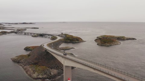 Magnificent View Of Atlantic Ocean Road in Norway With Cars Crossing The Bridge On a Cloudy Day. - Aerial orbit