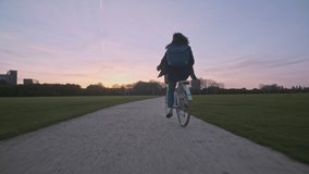 Follow shot of young woman cycling on a gravel path at sunset - Powered by Shutterstock - Get 15% off with code: PIKWIZARD15